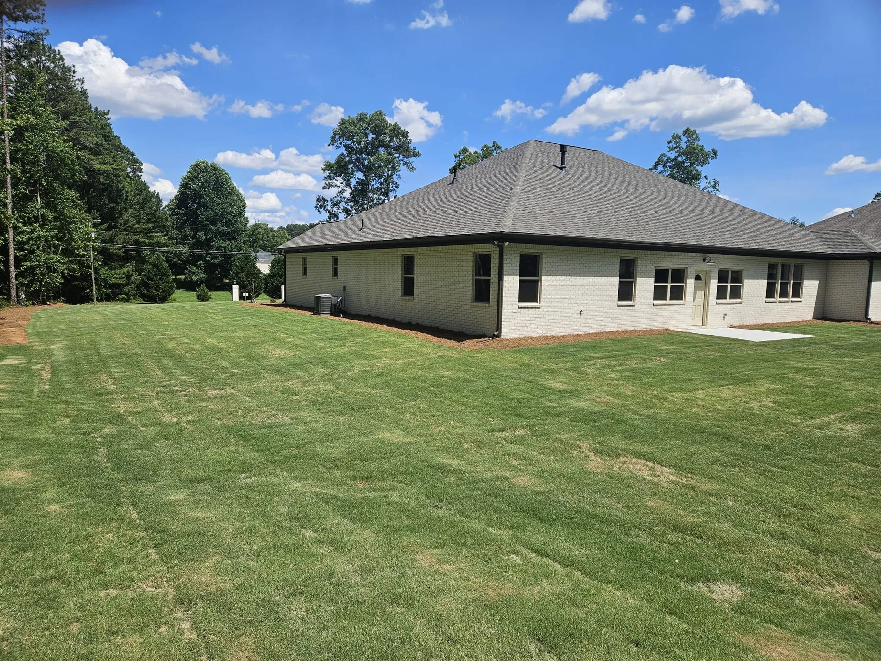 Rear view of a finished home and lawn by Peters Prestigious Properties Inc.