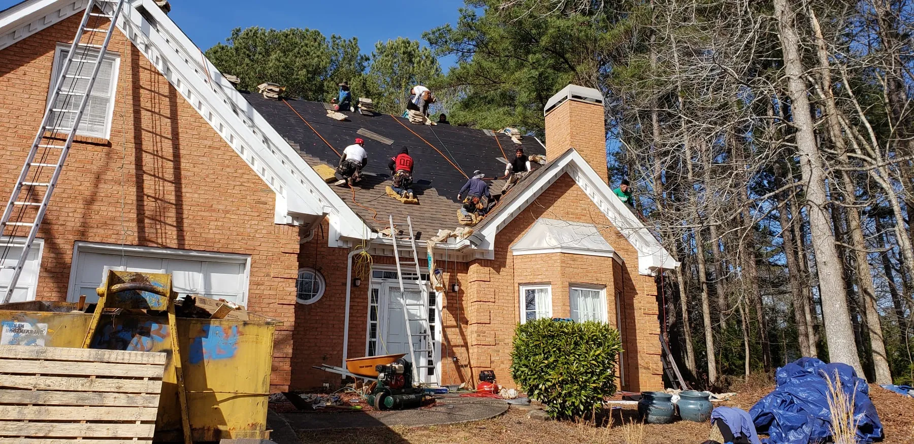 Roofing crew working on a brick home for Peters Prestigious Properties Inc.